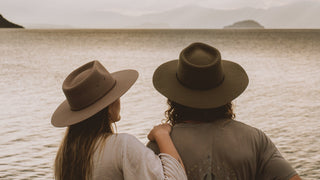 Couple wearing Will & Bear wide brim hats looking out over the water – timeless, nature-ready headwear made for slow travel and outdoor connection.