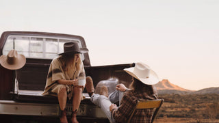 Man and a woman wearing a cowboy hats in the desert