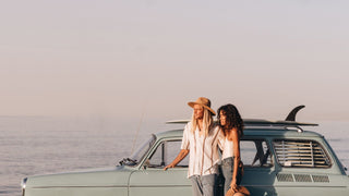 A couple with wearing sun hats by Will & Bear, summer beach with ocean in the background