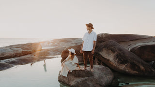 Man standing with his girlfriend at the beach while wearing a vacation or holiday hat by Will & Bear