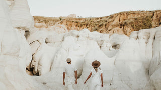 A couple in all-season wool hats by Will & Bear explore white cliffs together.