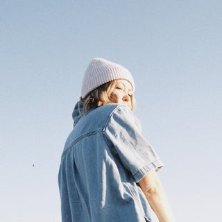 Woman wearing the Will & Bear Bambi Dust Blue Australian wool beanie in the sunshine, perfect for lightweight warmth.