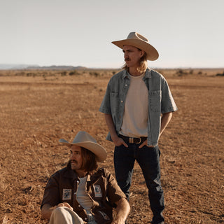 Man and woman in open country wearing Will & Bear white cowboy hats felt, styled for road trips and dusty trails.