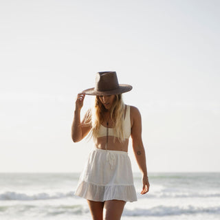Woman wearing Will & Bear Brown Straw Wide Brim Hat during golden hour on the beach