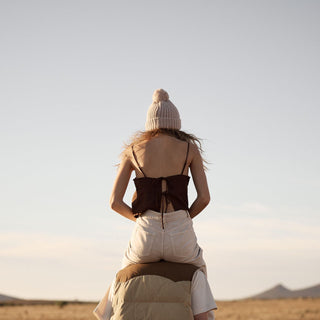 Will & Bear off white chunky knit beanie worn during outdoor adventure, woman riding on shoulders in desert landscape