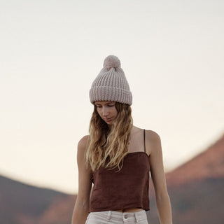 Will & Bear off white chunky knit beanie worn by woman outdoors, with mountain backdrop at sunset
