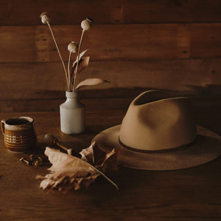 Will & Bear Anderson Camel Floppy Felt Fedora styled with rustic travel essentials on a timber table