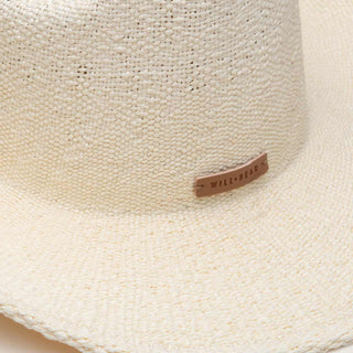 Close-up detail of the Will & Bear white straw cowboy hat showing the woven straw texture and leather brand tag.
