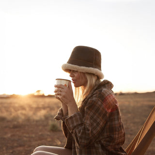 Woman wearing Will & Bear Brown Wool UGG Bucket Hat – Teddy Brown – cozy dawn moment in the Australian outback.