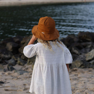 Child Standing by Water Wearing Will & Bear Kids String Bucket Hat – Eco-Friendly Bucket Hat for Kids.