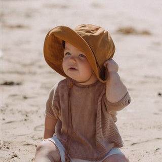 Toddler in Will & Bear Kids String Bucket Hat – Rust Orange Bucket Hat with Chin Strap for Beach Adventures.