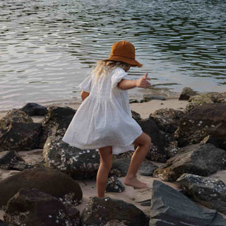 Child Climbing Rocks in Will & Bear Kids String Bucket Hat – Adventure-Ready Cotton Bucket Hat for Kids.
