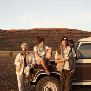 Group of friends beside a 4x4 vehicle on a desert road trip in Levi Dark Brown beanie
