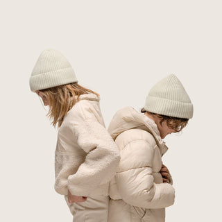 Boy and girl standing back to back wearing Little Bambi Sage Green Beanie