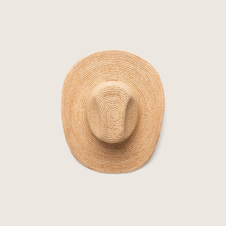 Straw cowbboy hat on a light beige background