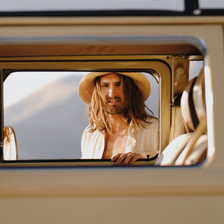 Woman road-tripping in Will & Bear Crushable Straw Bucket Hat, made for adventure and travel