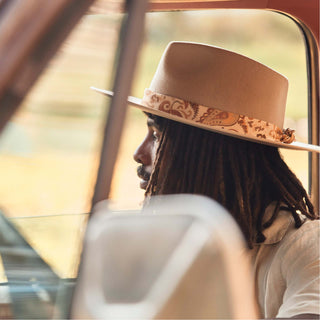 Man wearing the Will & Bear Hat Scarf Mustard on a hat viewed through a car window, scarf visible as focal detail.