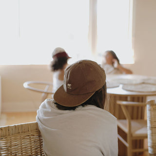 Child Wearing Will & Bear Kids Brown Cap Backwards – Little Ranger Brown Cap at Café Table.