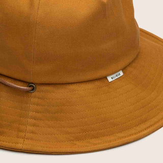 Close-up detail of the Will & Bear Lenny Rust Orange Bucket Hat showing chin strap and stitch work on brim.