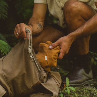 Will & Bear Lenny Rust Orange Bucket Hat packed into a travel bag, showcasing its flexibility and adventure-ready design.