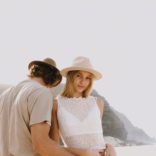 Couple at the beach wearing Will & Bear hats, woman wearing William Cream white felt fedora hat – designed for slow living.