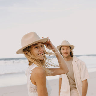 Woman smiling in Will & Bear William Cream felt fedora hat – naturally breathable wool for coastal travel and summer hikes.