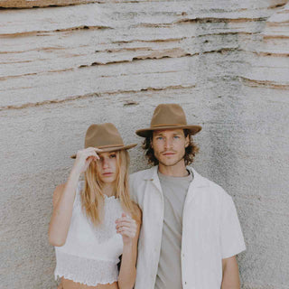 Couple standing together wearing Will & Bear hats – woman in William Cream, man in William Oak light brown crushable travel hat.