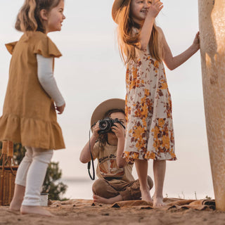 Kids at the beach wearing Will & Bear Australian Wool Kids Fedora – Little Calloway Cream in a playful, nature-filled moment.