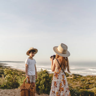 Children wearing Will & Bear Australian Wool Kids Fedora – Little Calloway Cream looking out over coastal landscape.