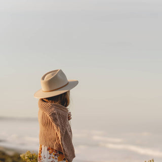 Girl wearing Will & Bear Australian Wool Kids Fedora – Little Calloway Cream looking out over a coastal cliff.
