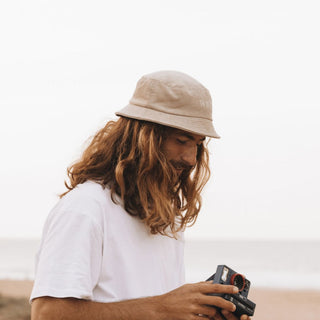 Man Wearing Will & Bear Perry Bone Beige Cord Bucket Hat – Lightweight Bucket Hat for Beach Adventures.