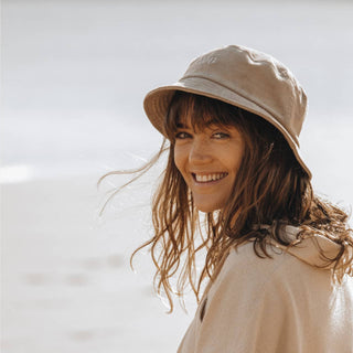 Woman Wearing Will & Bear Perry Bone Beige Cord Bucket Hat – Easy Fit Bucket Hat in Natural Light.