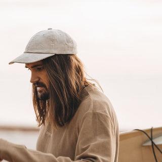 Man Wearing Will & Bear Parker Bone Beige Cord Dad Cap – Relaxed Fit for Coastal Adventures.