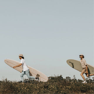 Friends in Will & Bear Parker Bone Beige Cord Dad Cap – Beachside Stroll with Surfboards.