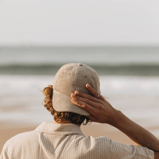 Man in Will & Bear Parker Bone Beige Cord Dad Cap – Looking Out at Ocean Horizon.