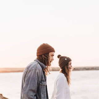 Couple wearing Will & Bear Brown Pom Pom Beanie – Tasman Brown – unisex winter hat for shared outdoor adventures.