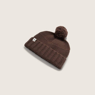 Will & Bear Brown Pom Pom Beanie – Tasman Brown – angled view showing ribbed cuff and oversized pom detail, displayed on neutral background.