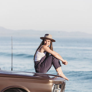 Ocean view adventure with woman wearing Will & Bear Felt Fedora Hat, made for sustainable travel