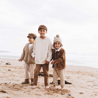 Children and adult walking on the beach wearing Will & Bear Kids Newsboy Cap – Little Baker Tan.