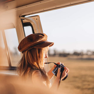 Girl wearing Will & Bear Kids Newsboy Cap – Little Baker Tan looking out a van window during a road trip.
