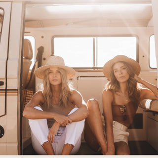 Women wearing Will & Bear Men's and Women's Straw Hats, resting in van after a beachside adventure
