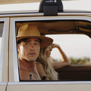 Man in car wearing Will & Bear Wide Brim Straw Hat – Sawyer Sand – timeless style for road trips and open-air living.