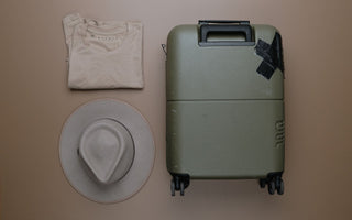 Person packing hat in carry on suitcase