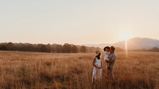 A family stands together in a field at dusk, each wearing a fedora hat by Will & Bear, creating a timeless silhouette.