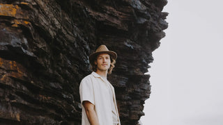 A man standing in front of a cliff wearing a Will & Bear fedora hat