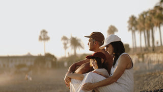 Family sitting at beach in their Will & Bear caps