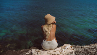 Woman wearing womens straw bucket hat by Will & Bear at the beach