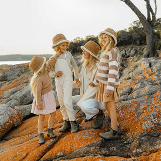 Family wearing the ugg wool bucket hat standing on rocks