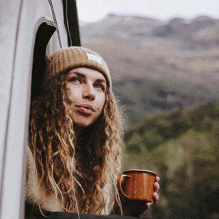 Women wearing wool beaning drinking cup of tea