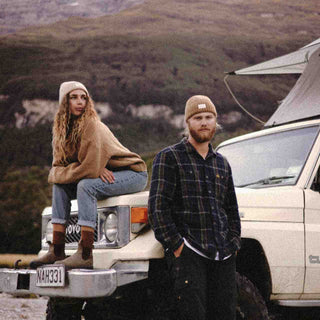 man and woman leaning against Toyota Land Cruiser wearing Australian wool beanies